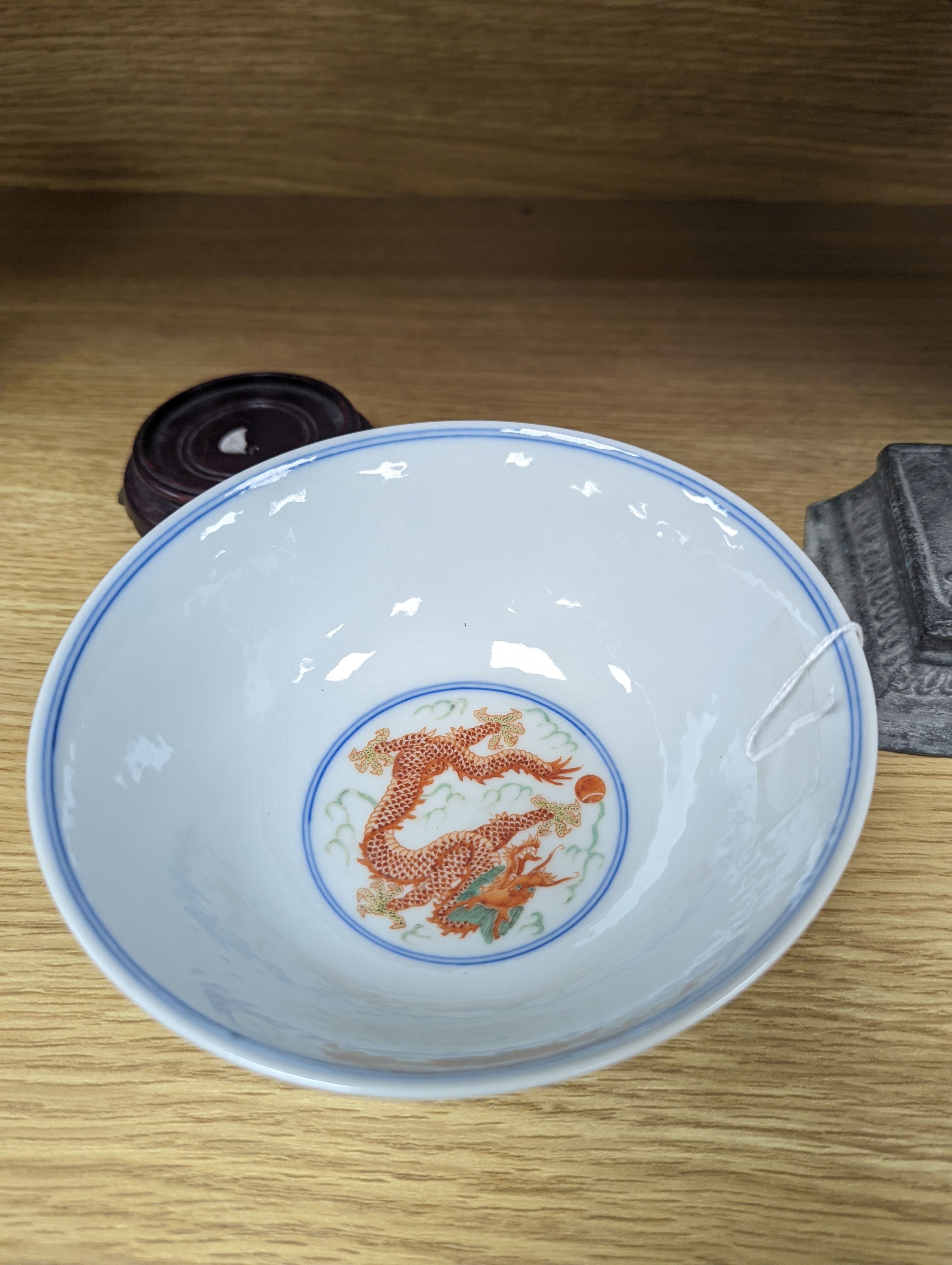 A Wucai bowl, dragon and flamingo pearl decoration, Jiaqing mark, on wood stand. 16cm diameter